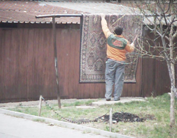 A man beating a carpet in Romania